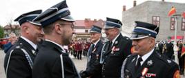 Widok z boku. Prezes Zarządu Oddziału Powiatowego Związku OSP RP w trakcie dekoracji strażaków OSP odznakami honorowymi.