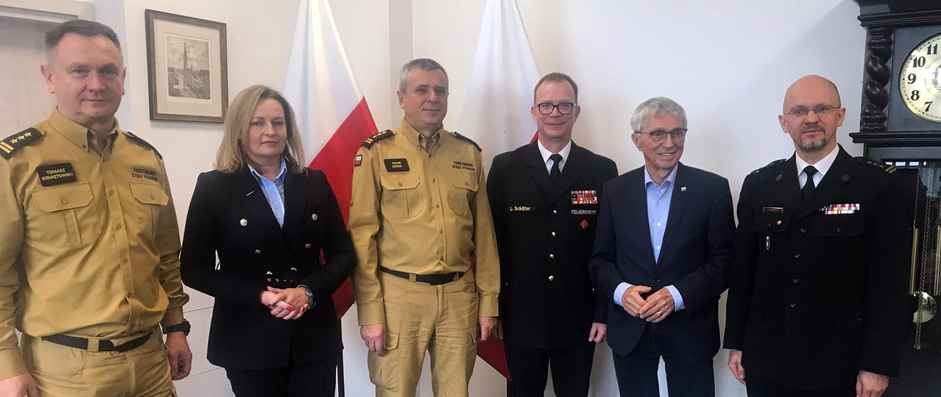 Przedstawiciele Państwowej Straży Pożarnej stoją wspólnie z przedstawicielami z Niemiec.