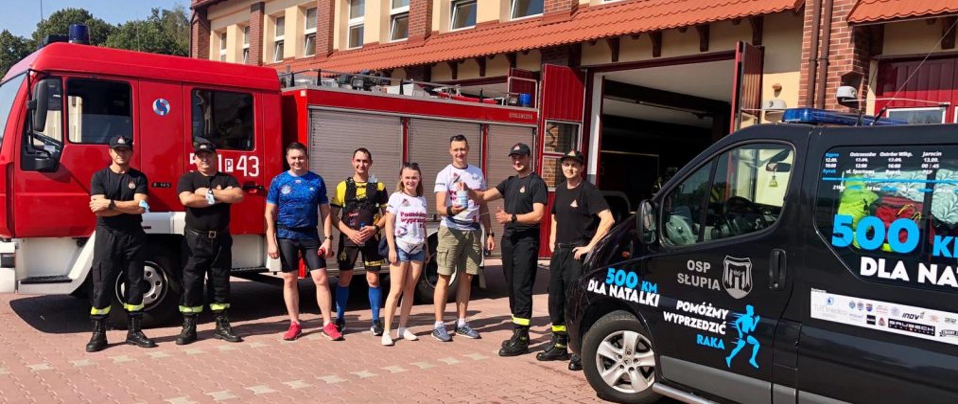 Na zdjęciu załoga Jednostki Ratowniczo-Gaśniczej w Ostrzeszowie przed strażnicą, która wita się ze strażakiem biegnącym dla chorej dziewczynki.