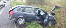 Widać uszkodzony samochód od strony pasażera w rowie