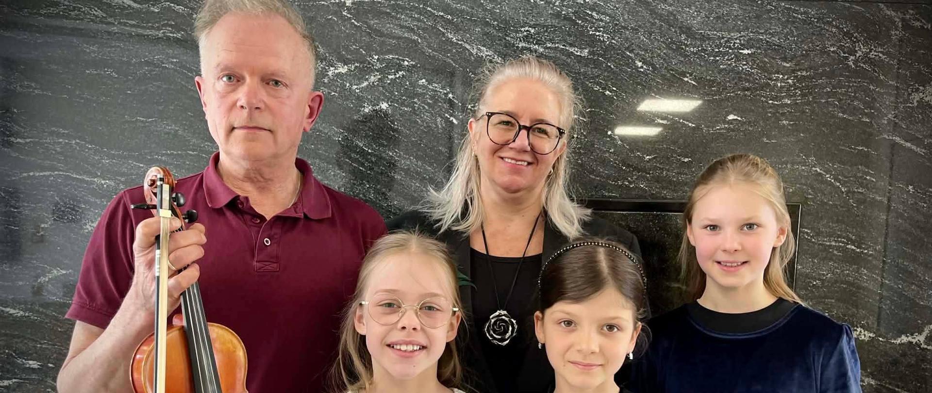 Piotr Bukowski i Beata Felczykowska wraz z trójką uczennic pozują na stojąco do zdjęcia