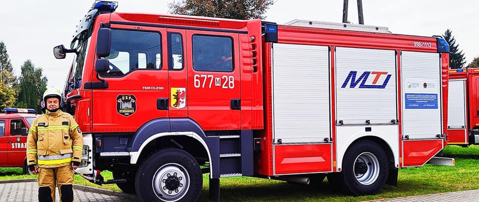 Na zdjęciu widać strażaka i samochód ratowniczo-gaśniczy