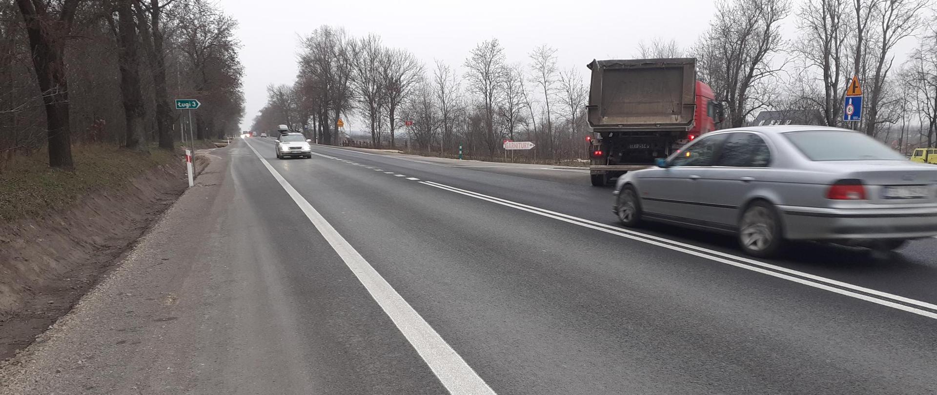 DK73 Suchowola - jednojezdniowa droga asfaltowa z podwójną białą ciągłą linią w środku, samochód ciężarowy skręca w prawo, osobowe jadą przeciwległymi pasami ruchu, każdy w swoim kierunku 