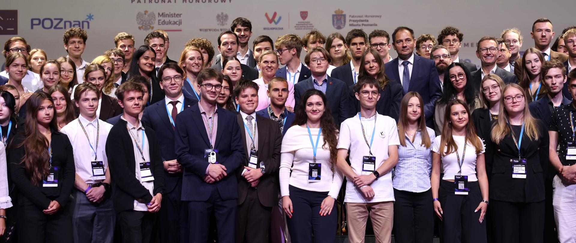 Minister Edukacji pozuje do zdjęcia grupowego z uczestnikami panelu.