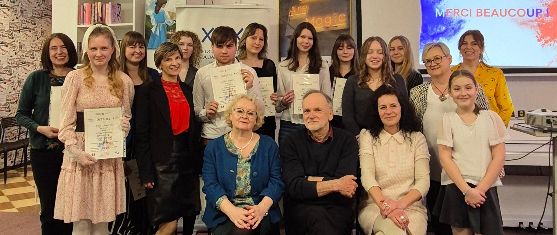 Zdjęcie grupowe, pozowane jury konkursu, uczestnicy i nauczyciele.