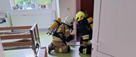 Pożar w budynku Ośrodka Opiekuńczo – Pielęgnacyjnego. Na pierwszym planie widać rotę z linią gaśniczą zabezpieczoną w aparaty ochrony układu oddechowego działającą wewnątrz budynku.