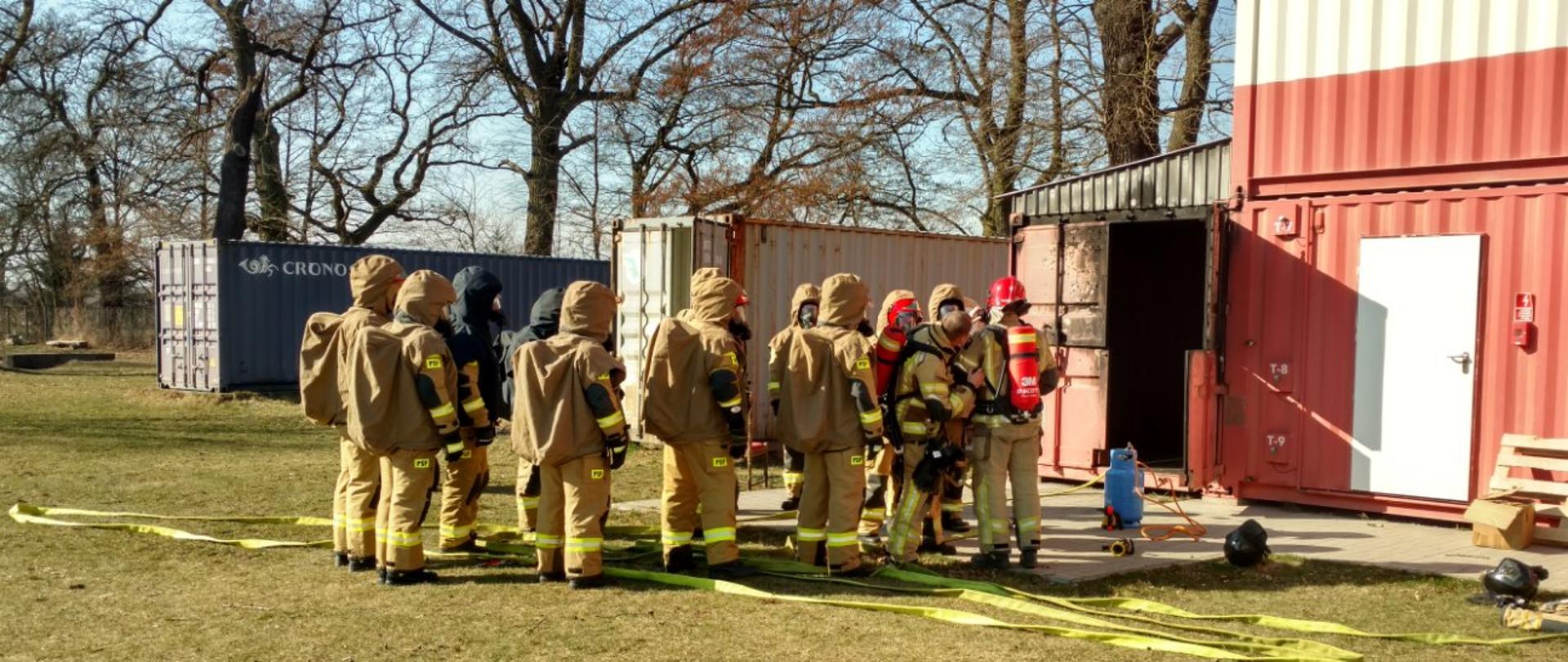 strażacy przed komorą ogniową