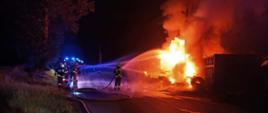 Jest noc, widać strażaków jak gaszą pożar opon