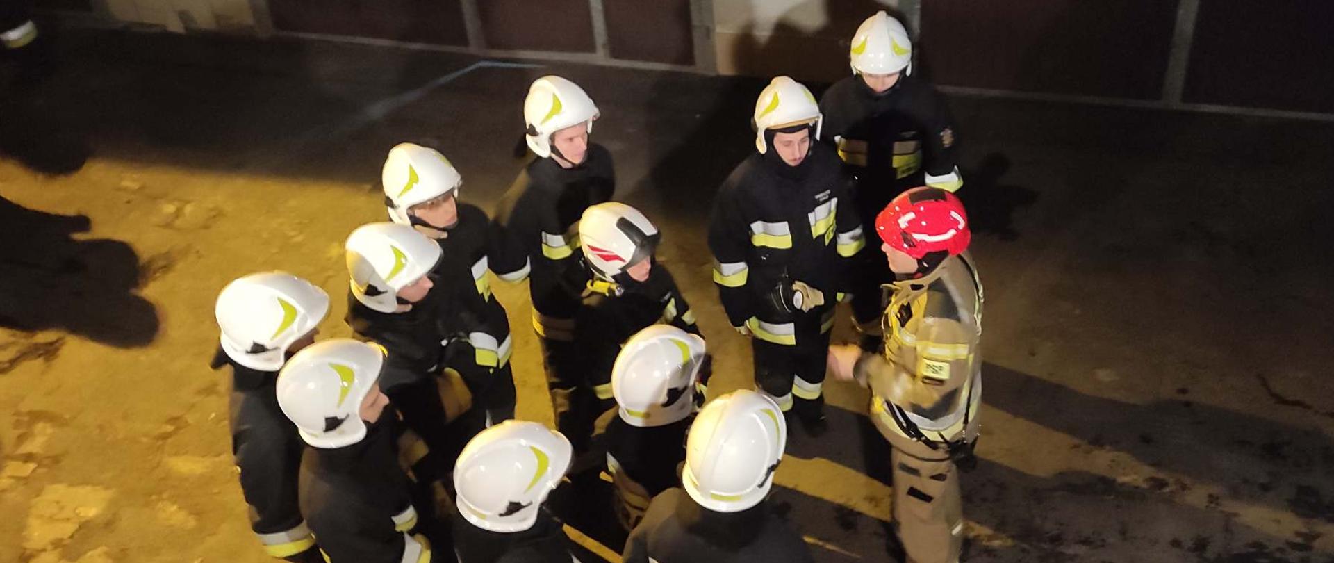 Na zdjęciu strażacy w ubraniach specjalnych w czasie odprawy przed ćwiczeniem