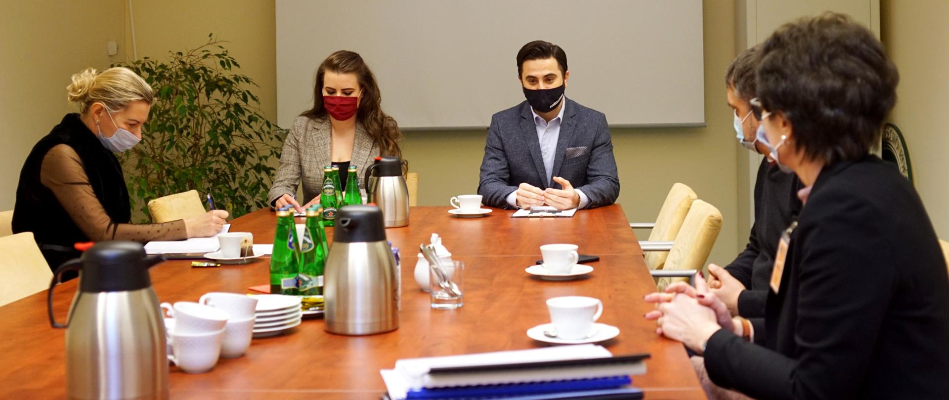 Wiceminister rolnictwa i rozwoju wsi Norbert Kaczmarczyk wraz przedstawicielami Instytutu Ogrodnictwa Państwowym Instytutem badawczym podczas spotkania w sali konferencyjnej. 