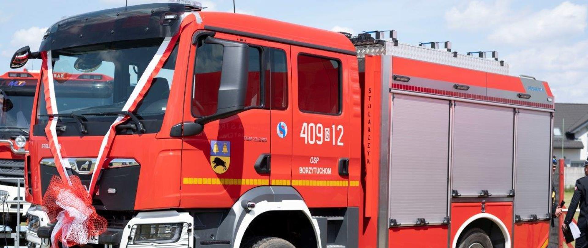 Czerwony pojazd pożarniczy marki MAN.