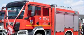Czerwony pojazd pożarniczy marki MAN.