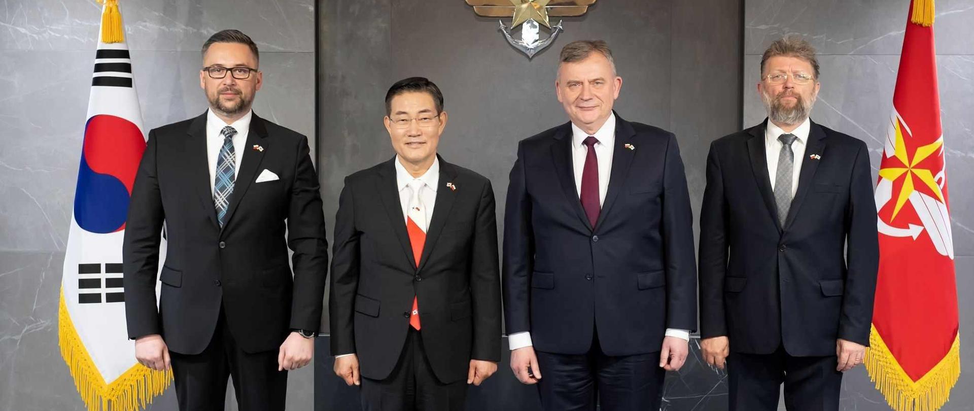 Cztery osoby stoją w garniturach