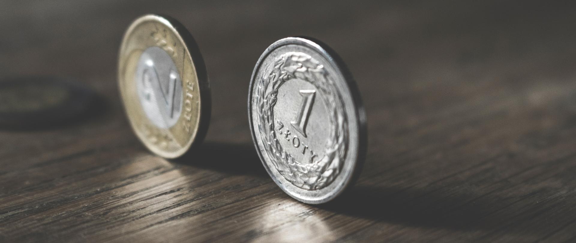 Moneta jednozłotowa oraz dwuzłotowa; stojące na stole