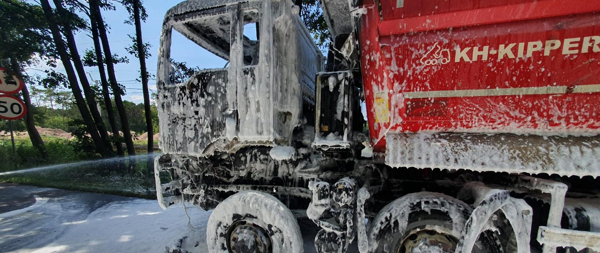 Zdjęcie przedstawia samochód ciężarowy pokryty pianą ciężką.