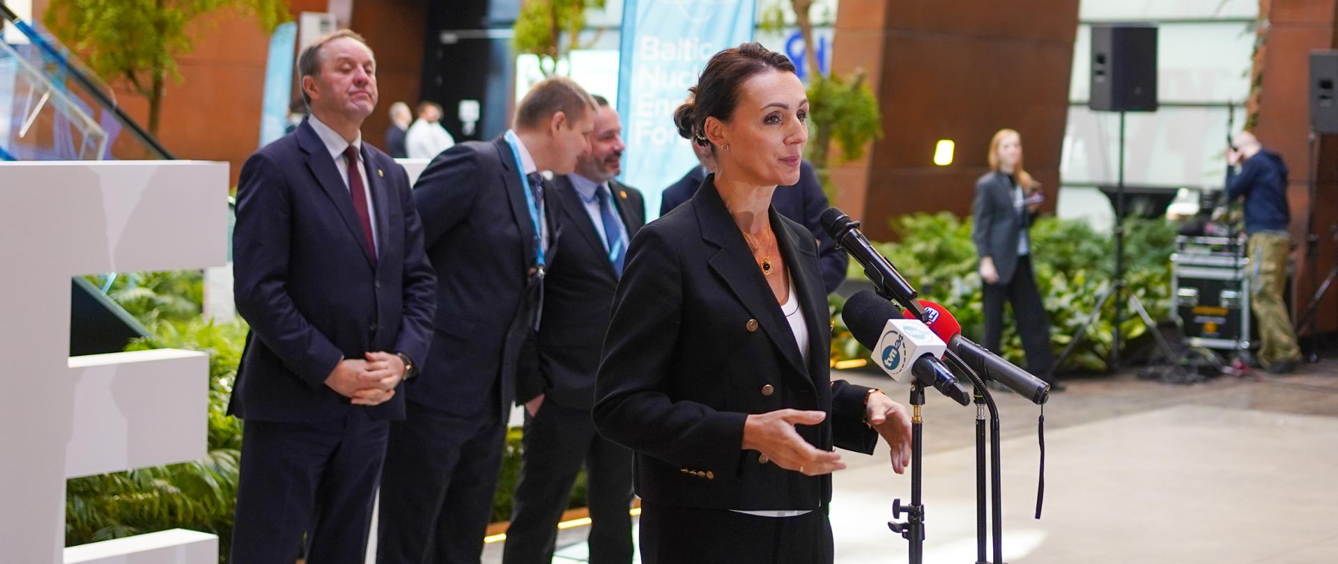 kobieta stoi przed mikrofonem i przemawia