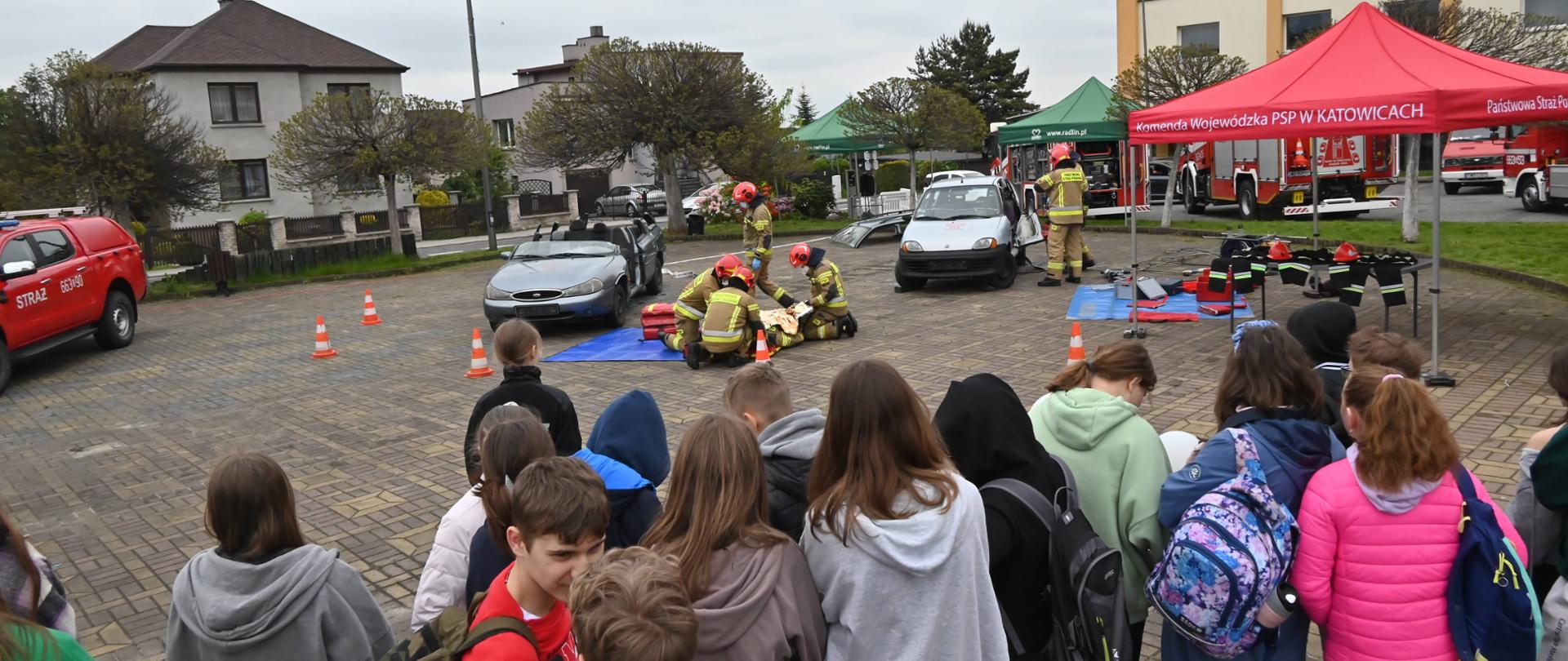 Strażacy w czasie pokazu ratowania osób zakleszczonych w pojazdach dla dzieci 