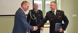 na zdjęciu widać przedstawiciela jednostki OSP, Komendanta PSP oraz Burmistrza miasta i gminy dziękujących za wzajemną współprace