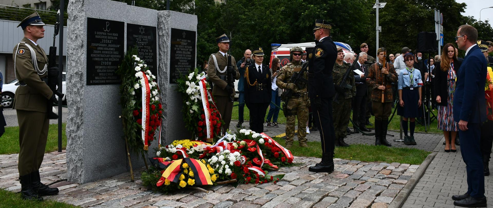 Na zdjęciu widoczny jest mężczyzna przed pomnikiem upamiętniającym wyzwolenie obozu koncentracyjnego „Gęsiówka”