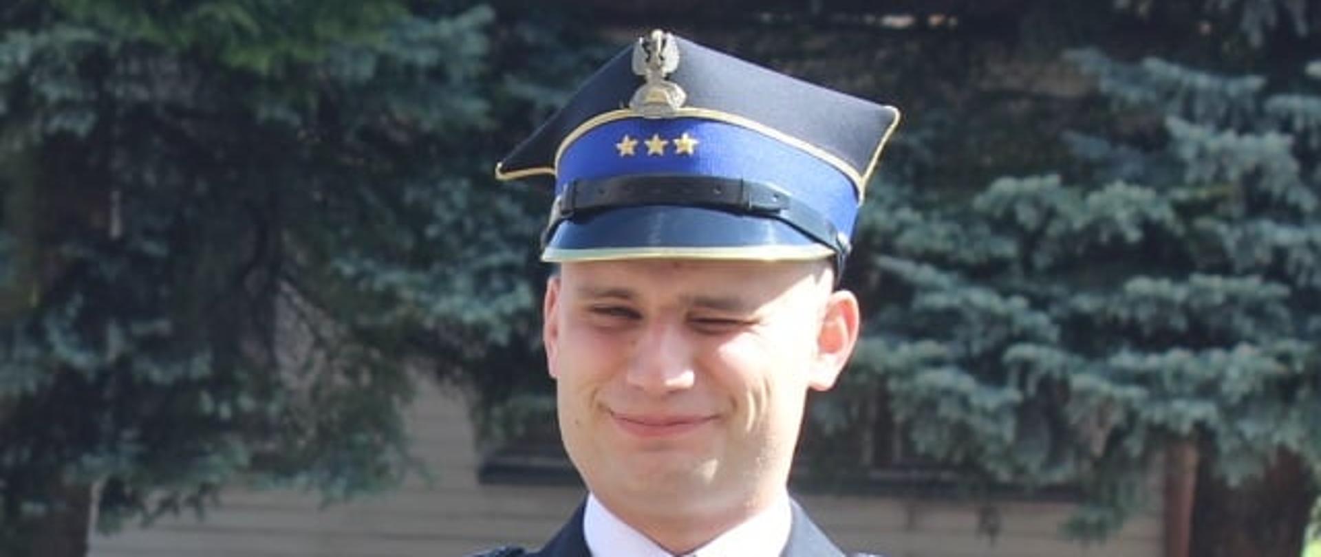 Na zdjęciu funkcjonariusz w mundurze wyjściowym 