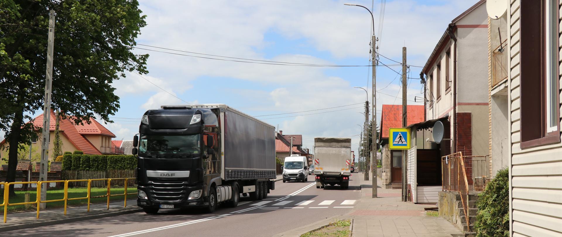 Ciężarówki przejeżdżają przez środek miejscowości. 
