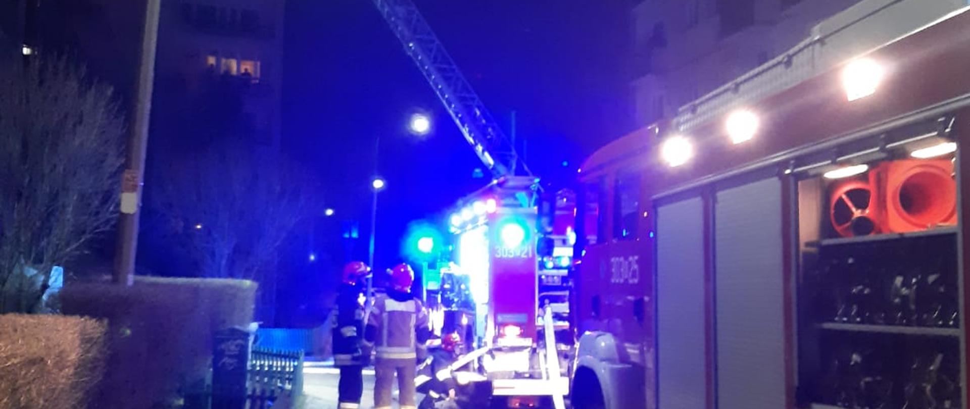zdjęcie przedstawia wozy strażackie podczas interwencji pożaru w mieszkaniu na 6 piętrze.