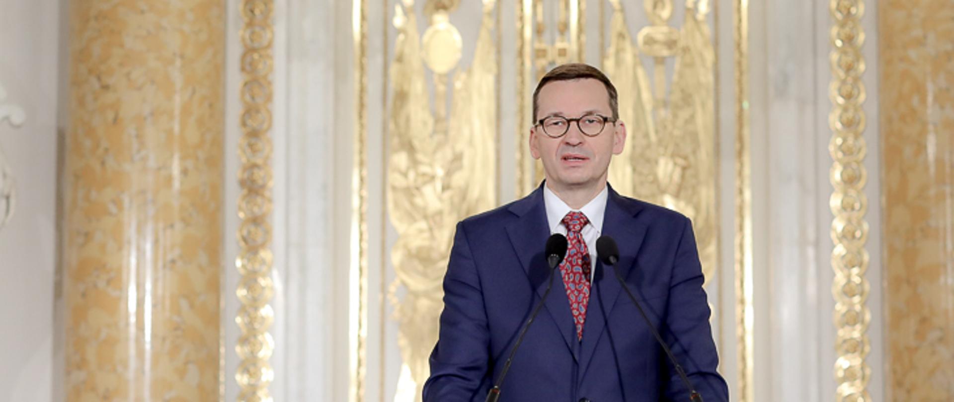 Premier przy mównicy na Zamku Królewskim.