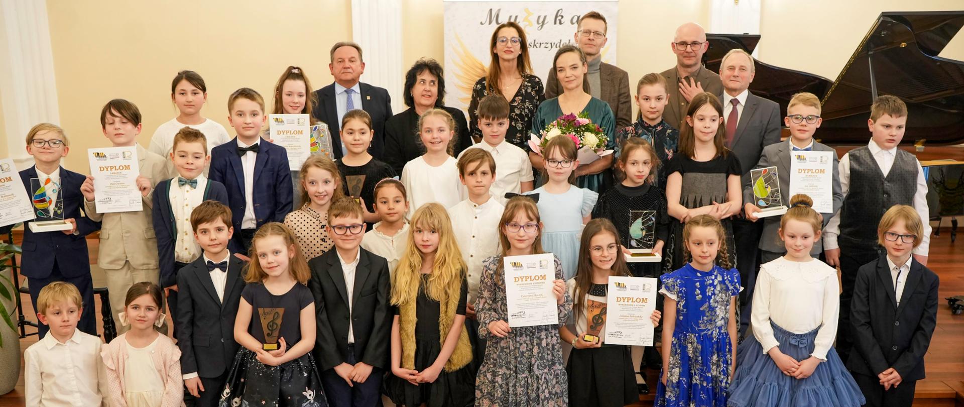 Burmistrz Miasta Lublińca, Przewodniczący Rady Powiatu, Pani Dyrektor, Jury wraz z uczestnikami XII Festiwalu Polskiej Muzyki Współczesnej dla Pianistów im. Janiny Garści w Lublińcu na sali koncertowej szkoły
