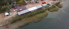 Zdjęcie wykonane z drona, które przedstawia zbiornik Honoratka oraz samochody strażackie i łodzie. 