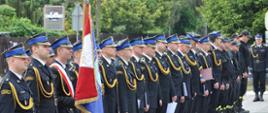 Pododdział strażaków ustawiony w dwuszeregu. 