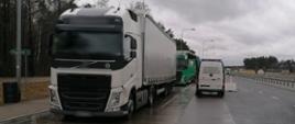 Zestaw ciężarowy zatrzymany do kontroli drogowej i stojący obok oznakowany furgon podlaskiej ITD.