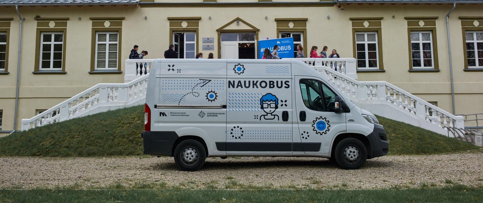 Naukobus zaparkowany pod budynkiem