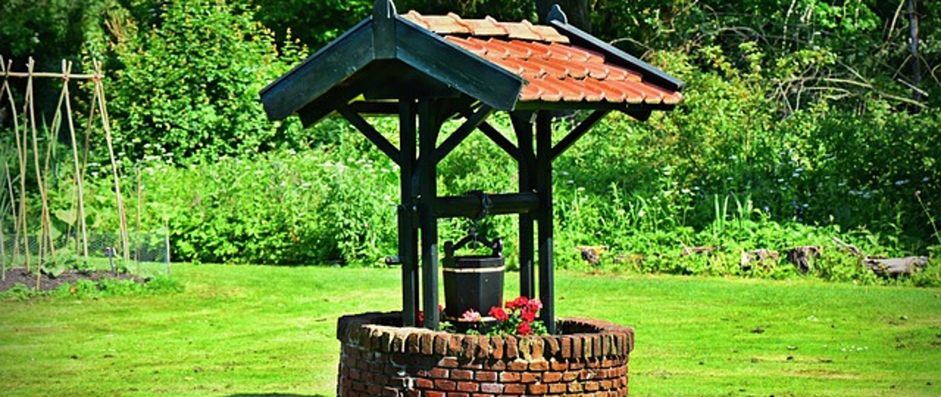 Zdjęcie przedstawia studnie w ogrodzie
