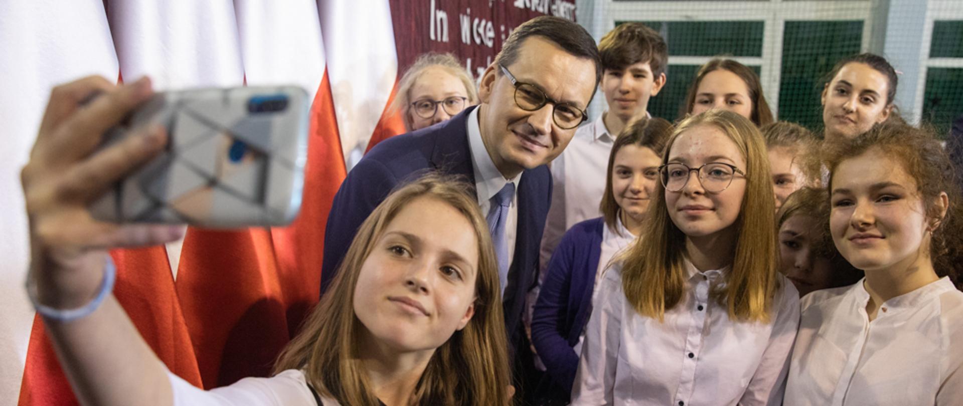 Uczennice robią pamiątkowe zdjęcie z premierem. 