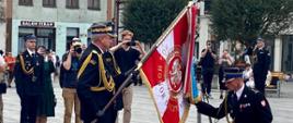 Na zdjęciu widać przekazanie sztandaru przez komendanta wojewódzkiego PSP w Gdańsku. Komendant powiatowy klęczy i trzyma róg sztandaru. 