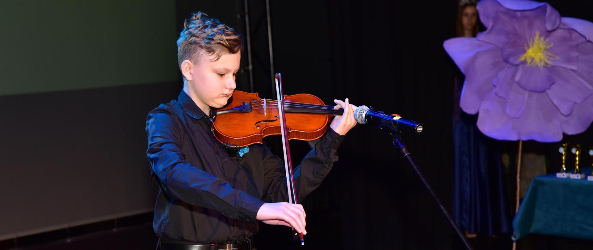 Zdjęcie przedstawiające ucznia - Antoniego Bulszę na skrzypcach podczas II Gali Talentów z okazji Dnia świadomości o Autyzmie pt. ,,Witajcie w naszej bajce", która odbyła się 17 kwietnia 2024 r. w Teatrze Starym w Bolesławcu.