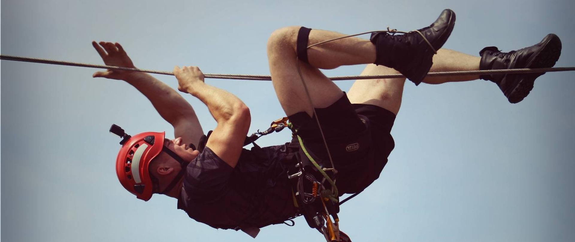 Wiszący ratownik wysokościowy na linie podczas zawodów