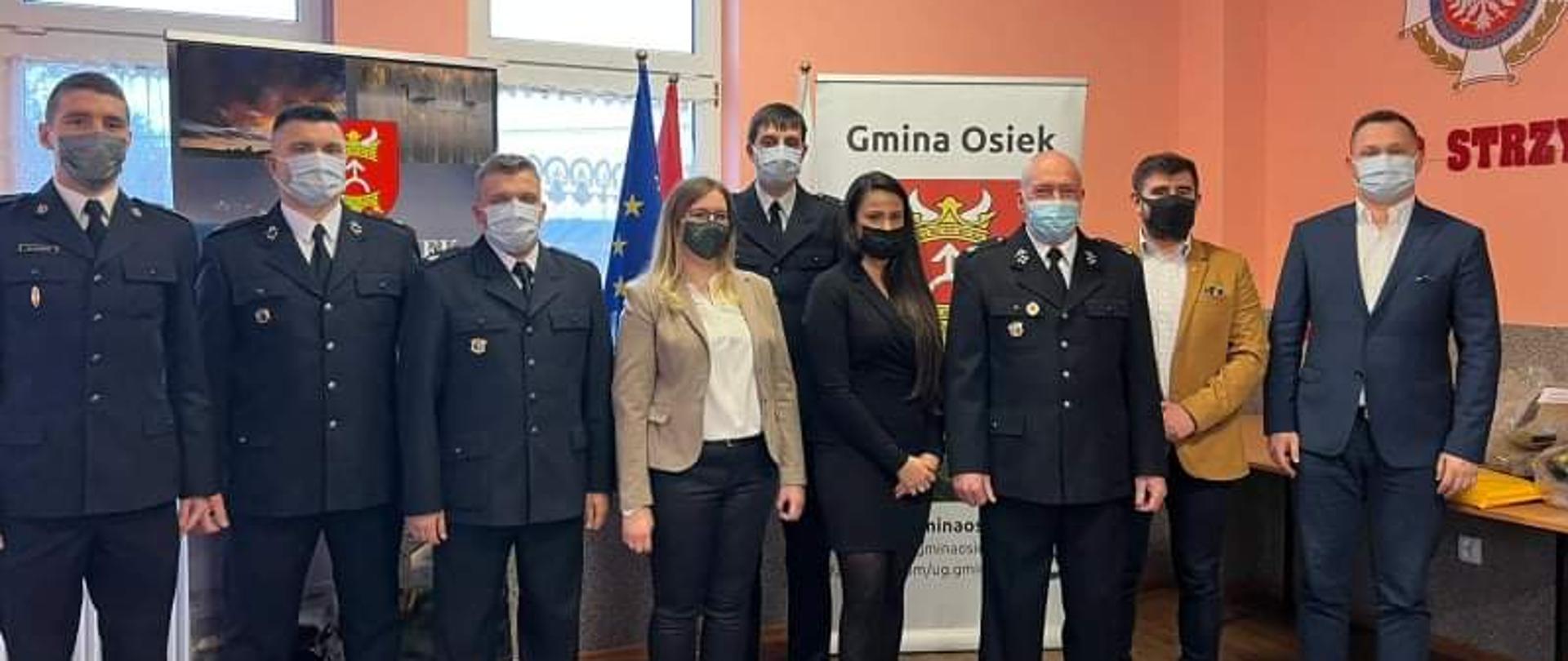 Zdjęcie przedstawia zgromadzonych gości podczas uroczystego przekazania sprzętu w świetlicy OSP Strzygi.