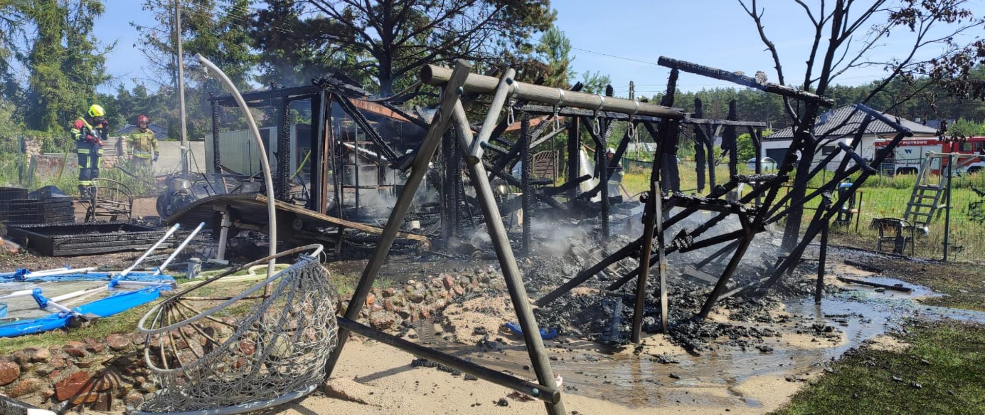 Spalony drewniany garaż i huśtawka