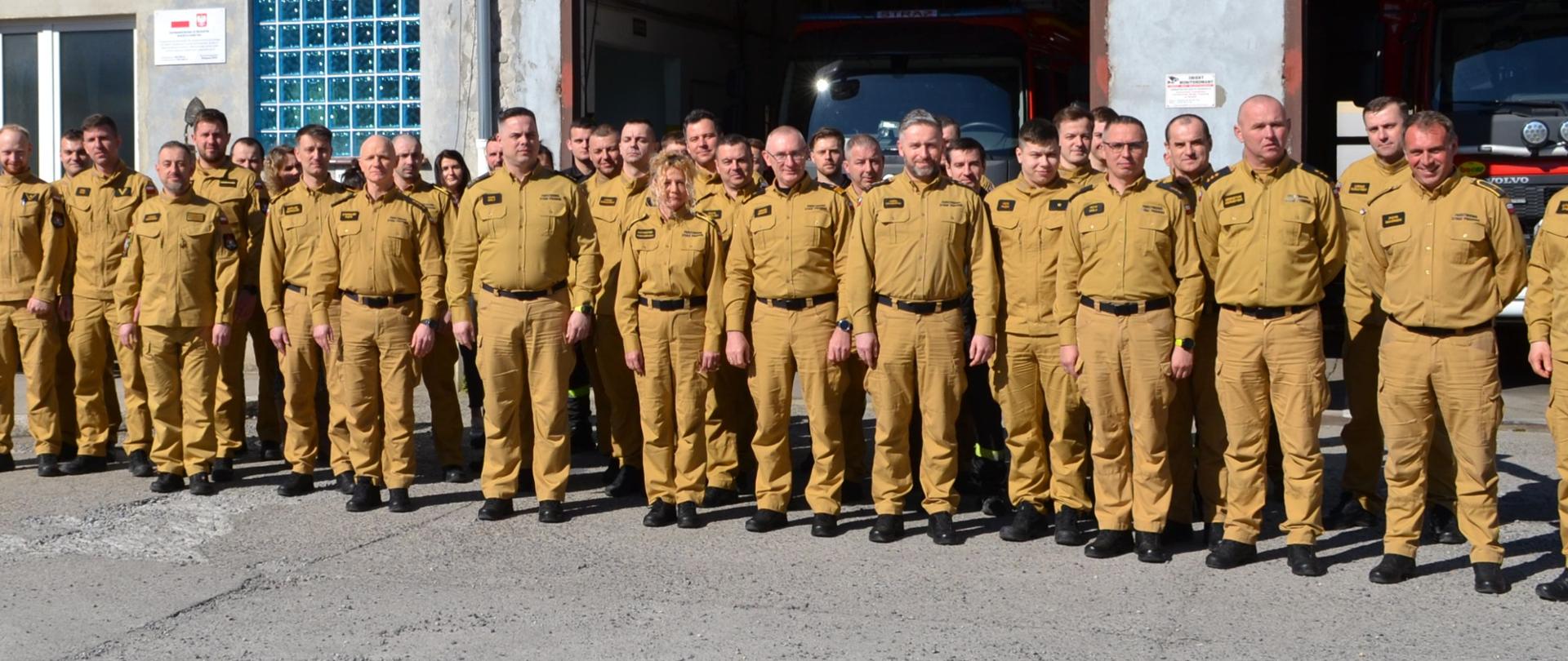 Na zdjęciu widoczni są strażacy i pracownicy uczestniczący w odprawie rocznej 