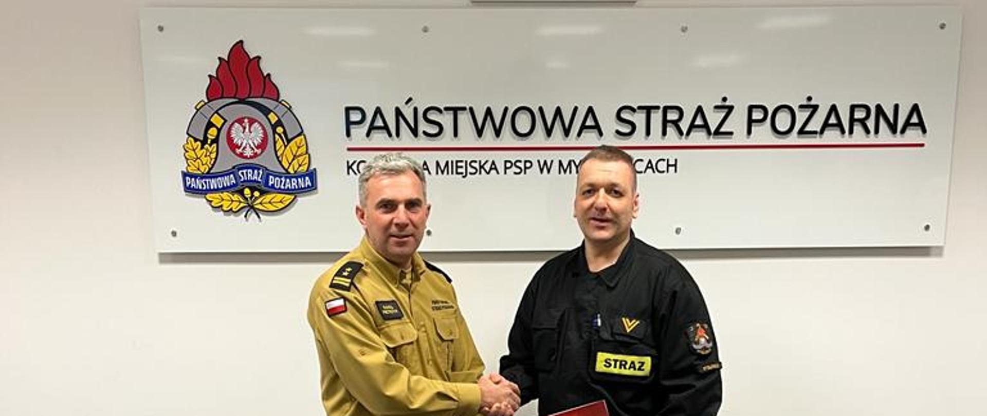 Zastępca komendanta PSP M-ce gratuluje strażakowi otrzymania nagrody
