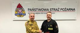 Zastępca komendanta PSP M-ce gratuluje strażakowi otrzymania nagrody