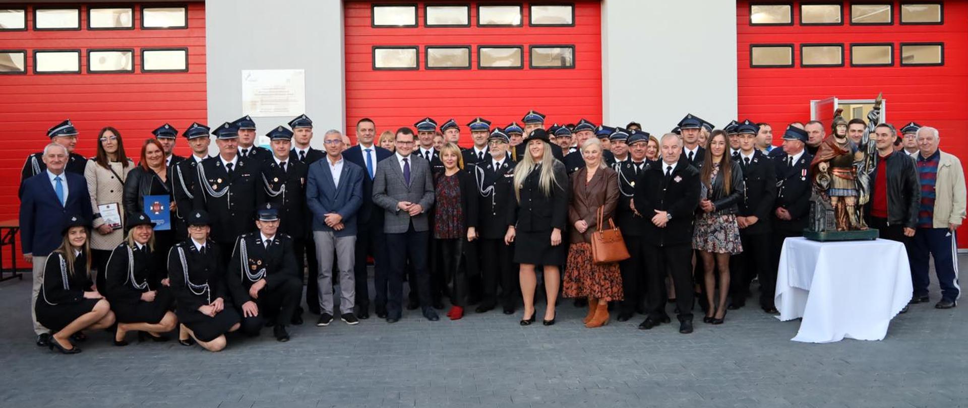 Zdjęcie grupowe na tle remizy OSP