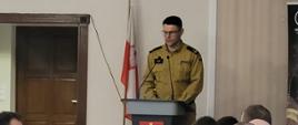 Zdjęcie przedstawia zastępcę Komendanta Wojewódzkiego Państwowej Straży Pożarnej we Wrocławiu mł. bryg. Michała Piętę podczas przemówienia. 