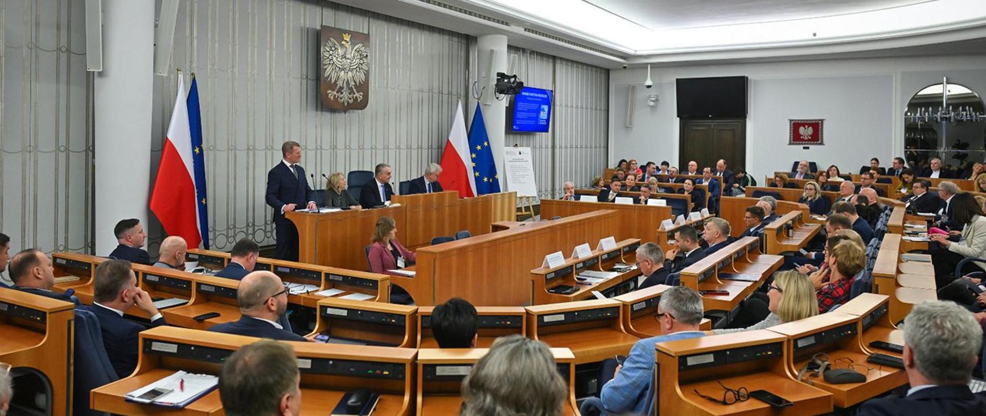 Picture showing the full chamber of the Polish Senate with members sitting in their seats.