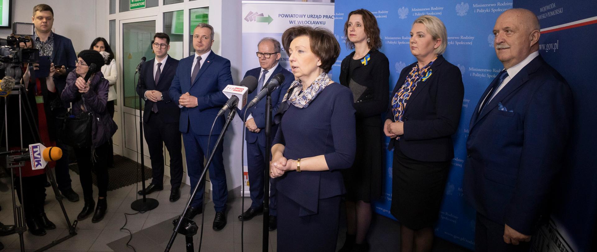 6 osób stojących przed mikrofonami