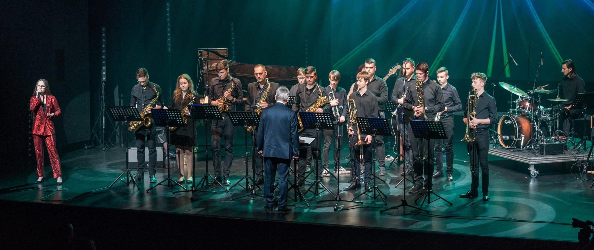 Big-band PSM w Koninie na scenie DK Oskard, dyryguje L. Pydyński, wokalista w czerwonym garniturze stoi z lewej strony