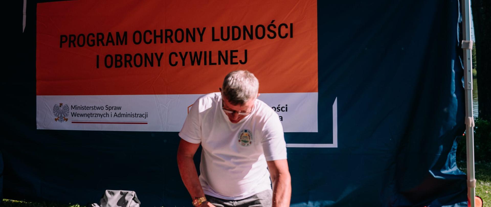 Mężczyzna klęczący przed fantomem