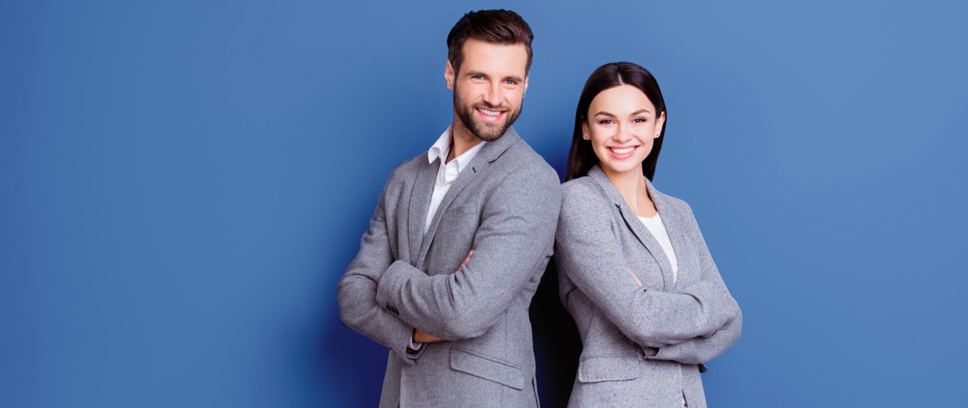 Na zdjęciu stoi pan z panią. Niebieskie tło.