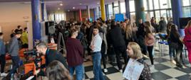 Uczestnicy XV Akademickich Targów Pracy. Na zdjęciu widać dużo ludzi, zarówno kobiet jak i mężczyzn. Dookoła, po lewej i po prawej stronie widać stanowiska pracodawców, do których można było podchodzić w trakcie wydarzenia. 